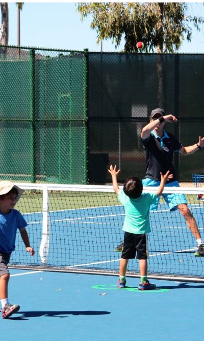 Nicolas Giachino playing tennis with kids